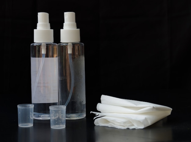 Hand sanitizer with tissue isolated on black background