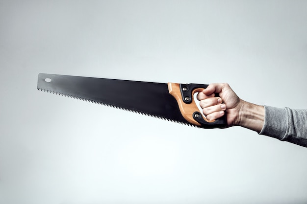 Hand saw isolated. Hand saw in the hand. Black hand saw in the hand