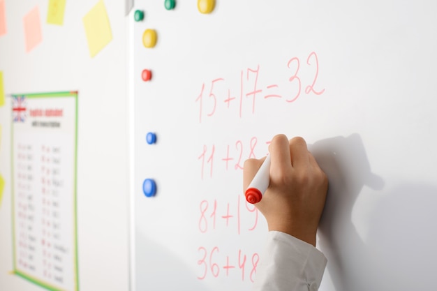 hand of a school girl learning counting numbers at the blackboard