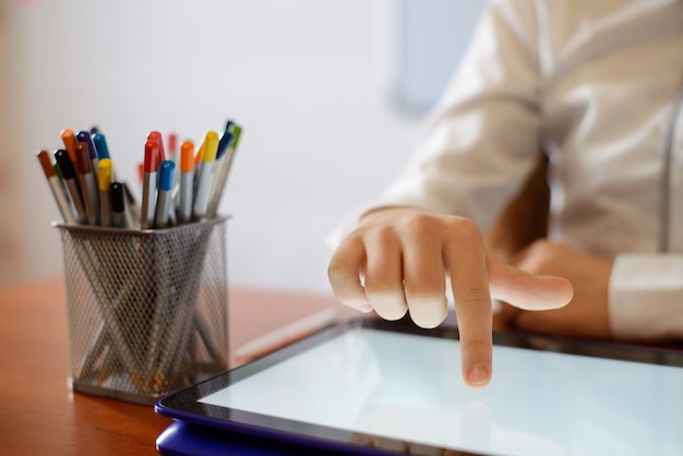 hand of a schoolgirl on a big screen of touch pad