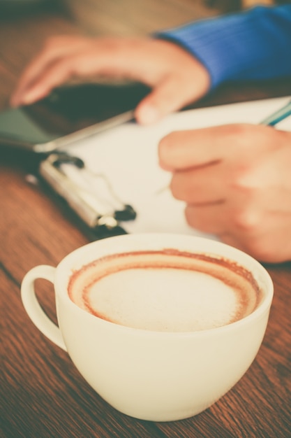 Hand schrijven met kopje koffie