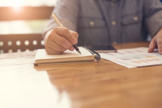 hand schrijven op notebook aan een bureau