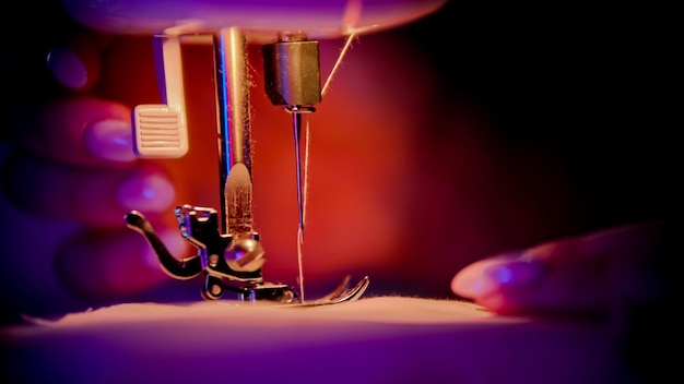 Hand of seamstress puts a cloth under the needle  sewing process