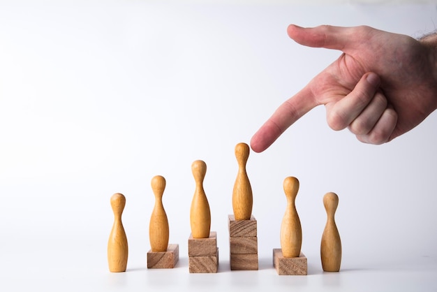 Hand selecting a wooden figure Business leadership concept