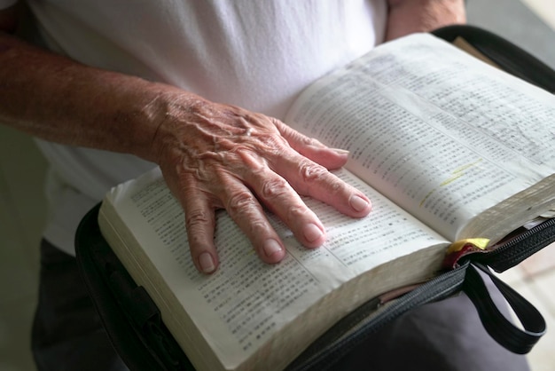 Hand of a senior man on an open book