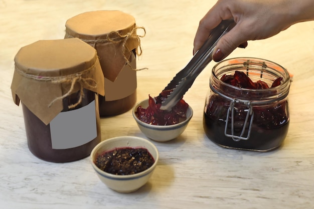 A hand serving homemade hibiscus jam in small bowls