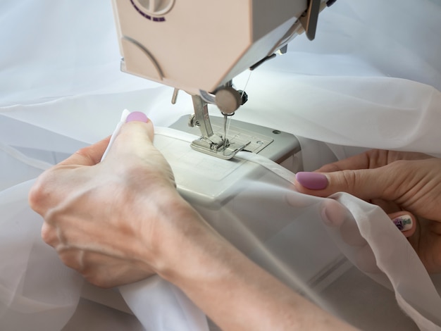 Hand sews a tulle on the sewing machine.