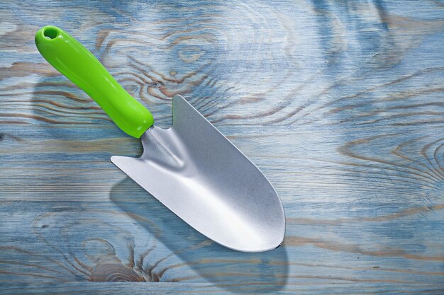 Hand shovel on wooden board gardening concept.