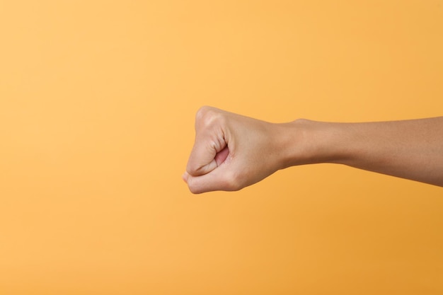 Hand showing fist isolated on pink background