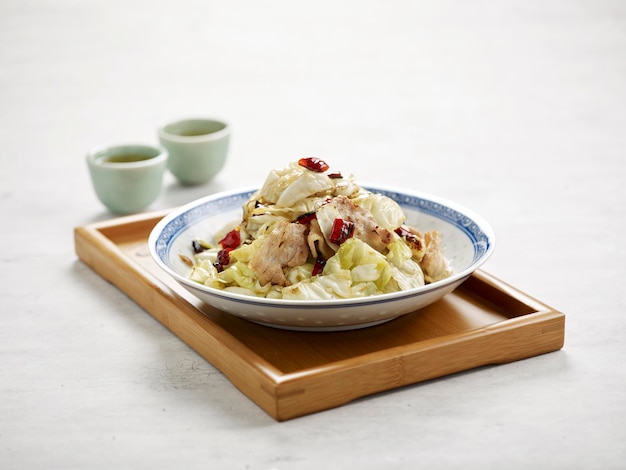 Hand Shredded Cabbage with pork cutlet in a dish isolated on wooden board side view on grey background