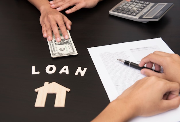 Photo hand sign document contract for loan to buy home.