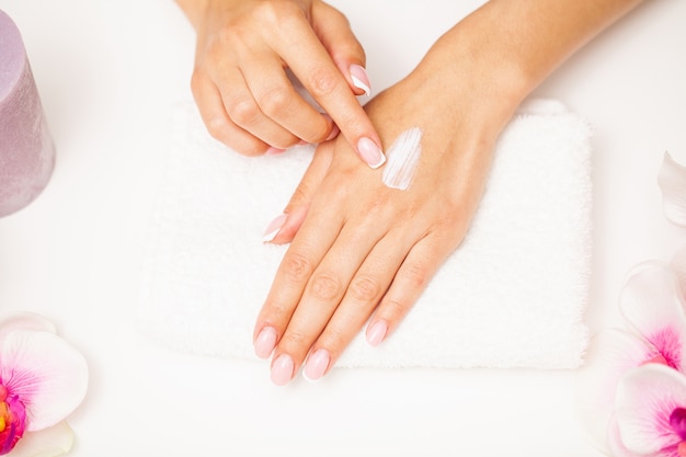 Hand skin care, woman applies moisturizer on soft silky skin