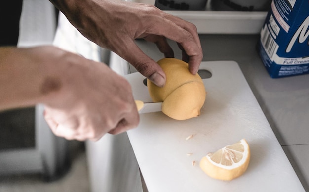 Photo hand slicing lemon with knife