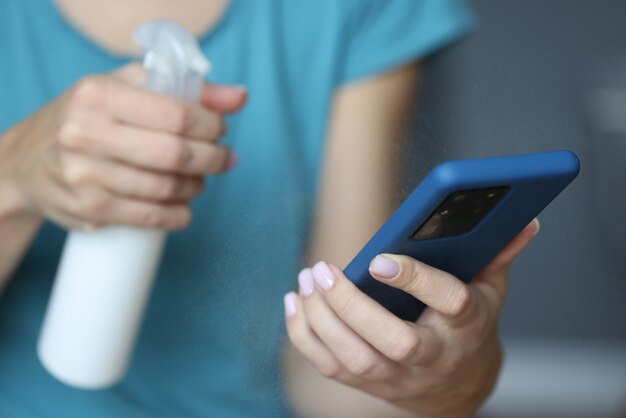 In hand smartphone is being sprayed with an antiseptic