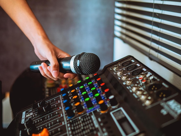 Hand Sound engineer holding microphone on sound mixer in live broadcasting studio producer for sound