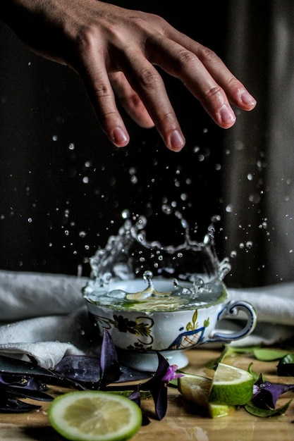 Foto la mano sopra il bicchiere d'acqua spruzzato