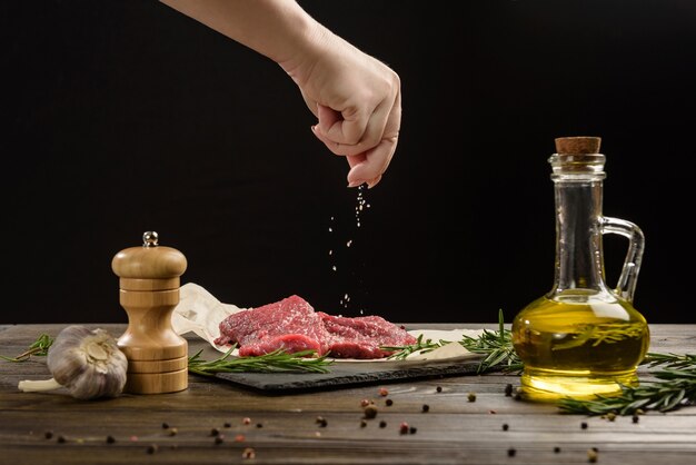 Hand sprinkle salt on beef steaks.