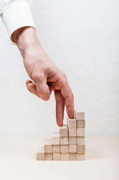 Photo hand stepping on wooden cubes concept