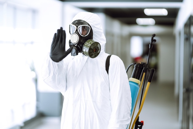 Foto hand stopbord. man in beschermend hazmat-pak toont stop-handgebaar voor het stoppen van de uitbraak van het coronavirus.