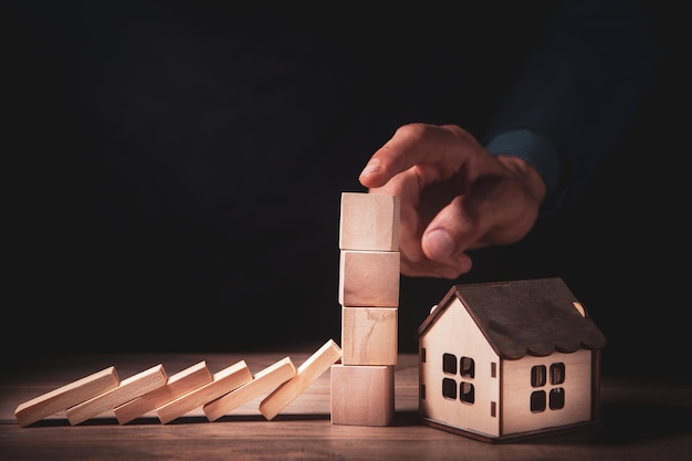 Hand stopping risk the wooden blocks from falling on house