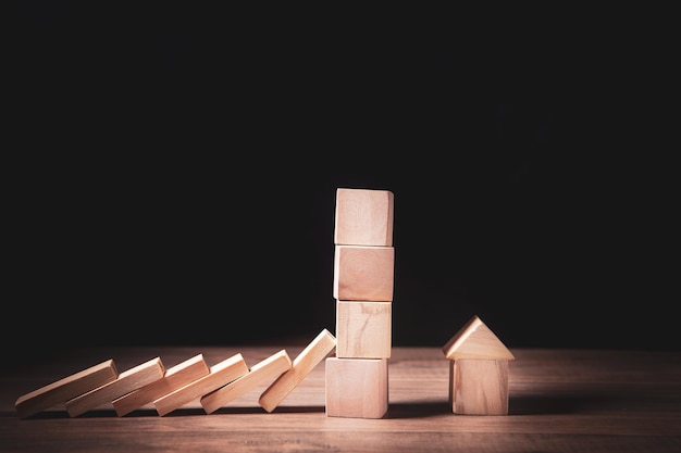 Hand stopping risk the wooden blocks from falling on house