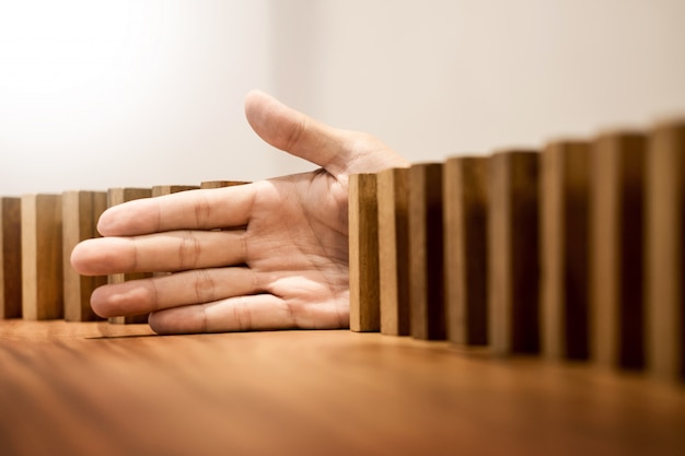 Photo hand stops dominoes blocks