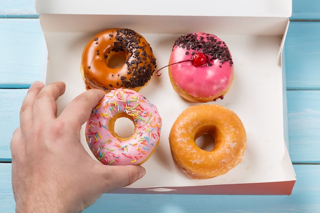 Hand takes donut out of the box