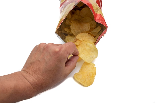 Рука берет чипсы из пакета с чипсами открытым и вид спереди С чипами внутри и снаружи пакета