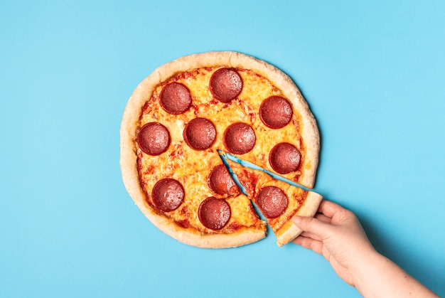 Hand taking a slice of pizza