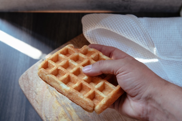 Hand taking a waffle from the plate