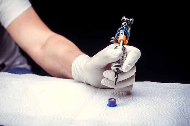 Hand of a tattooer, carefully holding a tattoo device.