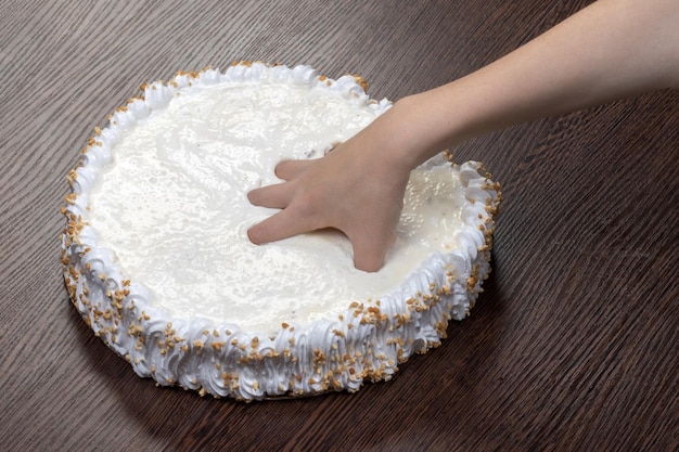 Hand tearing a large white cake