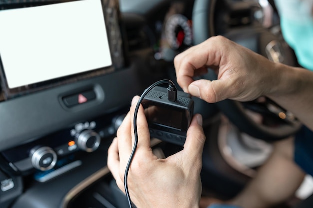 Hand of technician preparing and installing front camera car recorder inside car