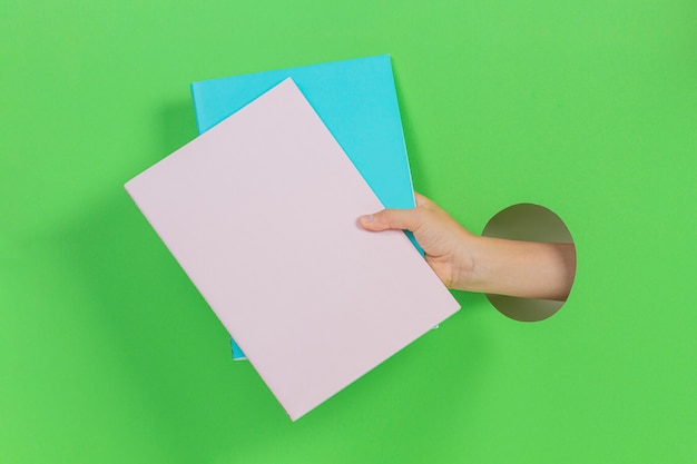 Hand through a hole holding paper