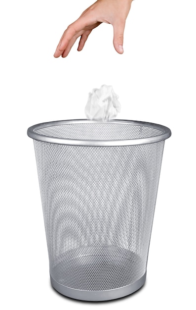 Hand throwing out paper into trash basket isolated on white