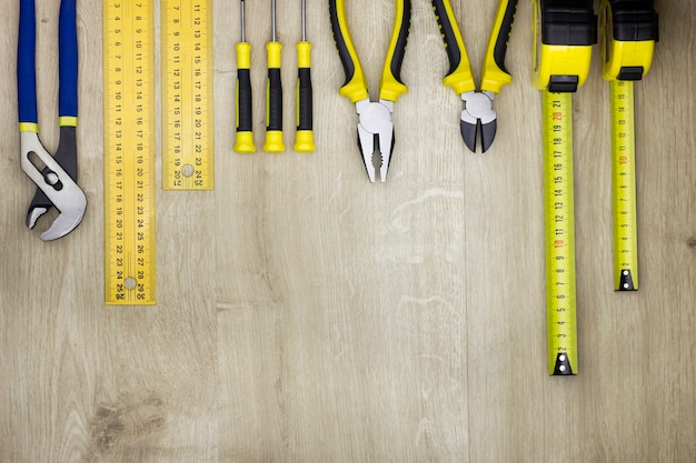 Hand tools in workshop on natural wood background. View from above with copy space.