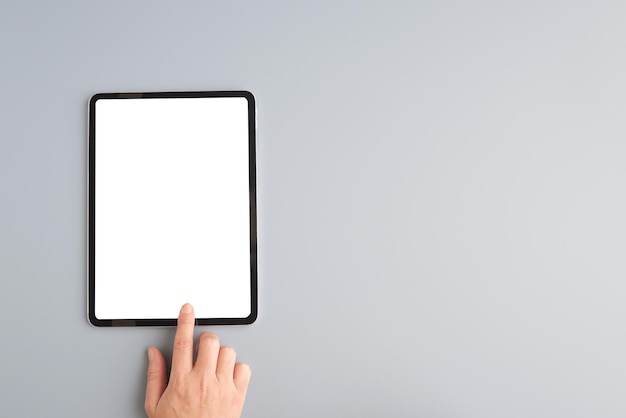 Hand touch digital tablet with blank on screen isolated on gray background