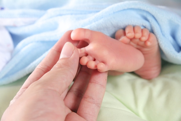 Foto mano toccare il piede del neonato