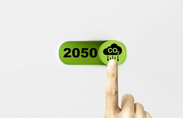 Toccare con la mano il pulsante di accensione e spegnimento verde con l'icona di riduzione di co2 e il numero 2050 per ridurre l'impronta di carbonio di co2 e il credito di carbonio per limitare il riscaldamento globale dal concetto di cambiamento climatico