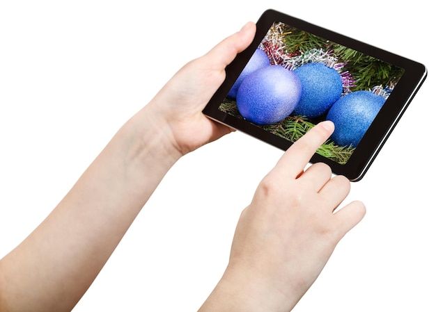 Hand touches tablet pc with Christmas decorations