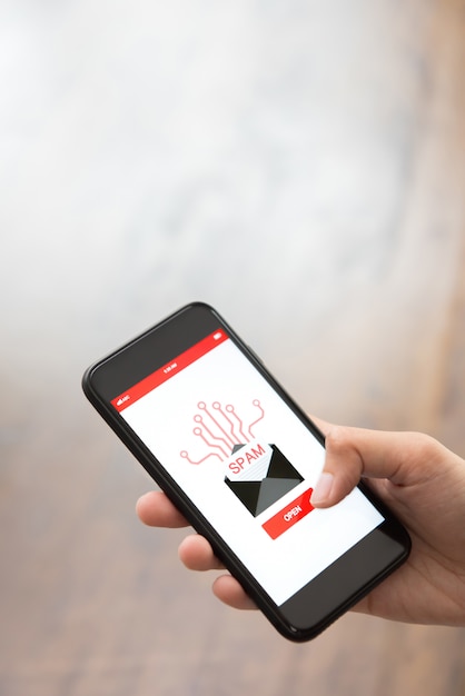 Passi il bottone commovente sullo schermo dello smartphone che controlla il email elettronico dello spam industriale
