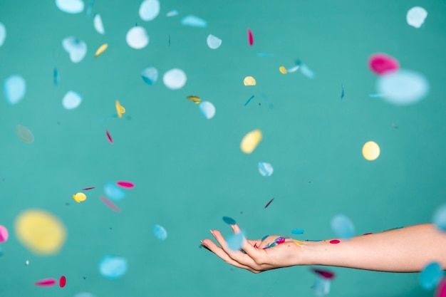 Photo hand touching the colorful confetti