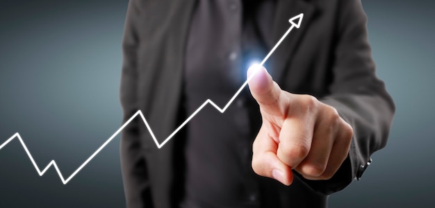 Hand touching graphs of financial indicator and accounting market economy analysis chart