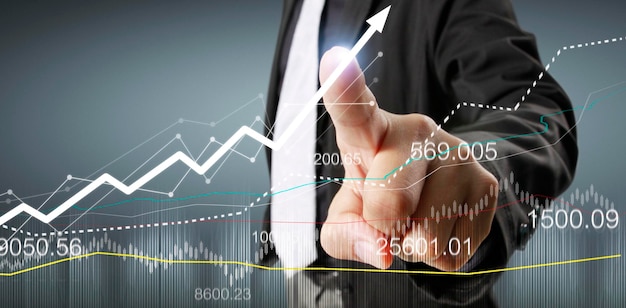 Hand touching graphs of financial indicator and accounting market economy analysis chart