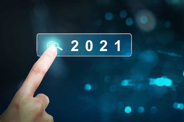 Hand touching the virtual screen of 2021. Happy New Year 2021