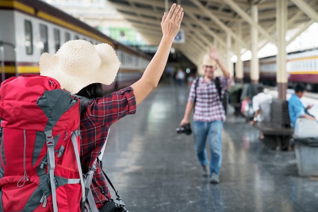 Photo hand of traveler girl saying hello to friend in the railway station.