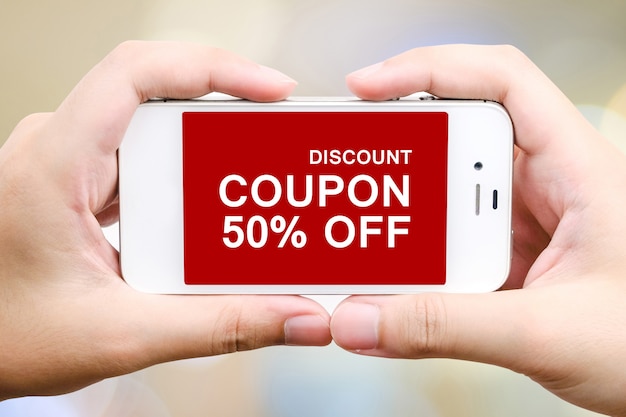Foto mano che digita codice coupon di sconto sullo schermo dello smartphone per ottenere la promozione dello shopping online