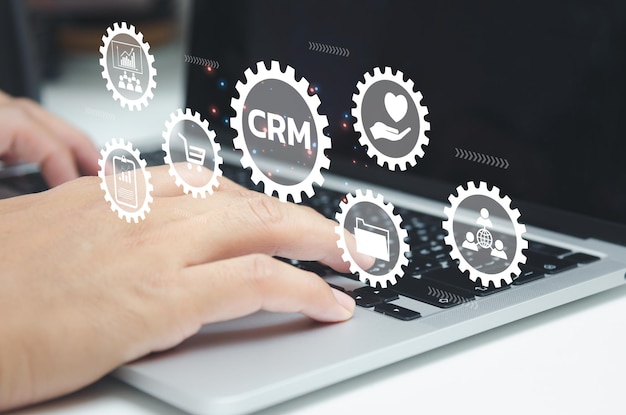 Hand typing on laptop concept Icons CRM Customer Relationship Management business on virtual screen