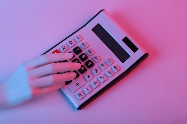 Photo hand uses calculator in pink blue gradient neon light