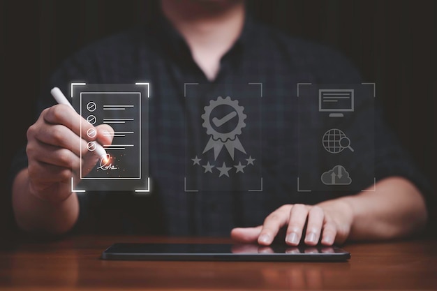 Photo hand using electronic for signature to document on virtual screen and document for online approve paperless quality assurance and erp management concept